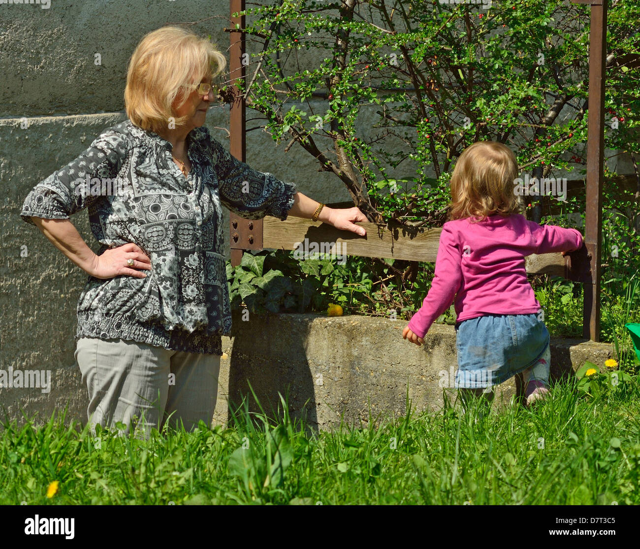 Bambina con la Nonna nel giardino soleggiato Foto Stock