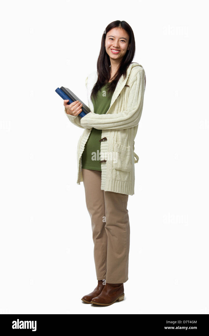 Sorridente studentessa trasporto di libri, ritratto Foto Stock