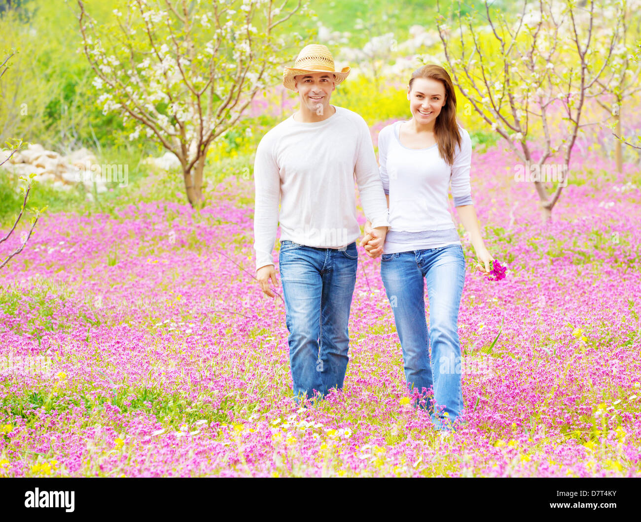 Due amanti allegro passeggiate nel giardino di primavera, avendo divertimento all'aperto, relax sul cortile, del romanticismo e del concetto di amore Foto Stock