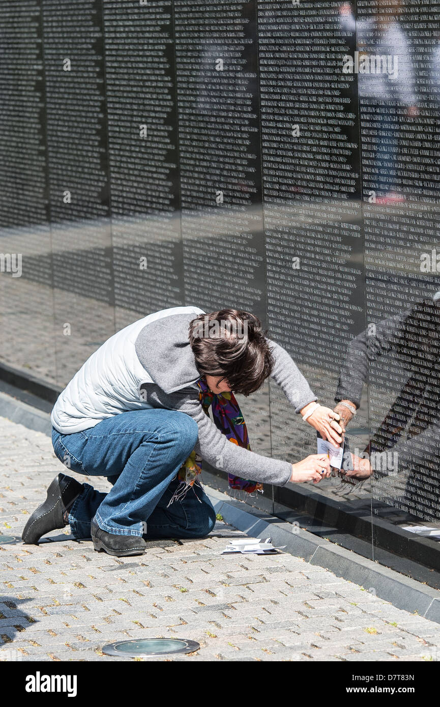 Le donne che prendono la tastatura del nome di famiglia dalla parete del Vietnam War Memorial, Washington DC, America, STATI UNITI D'AMERICA Foto Stock