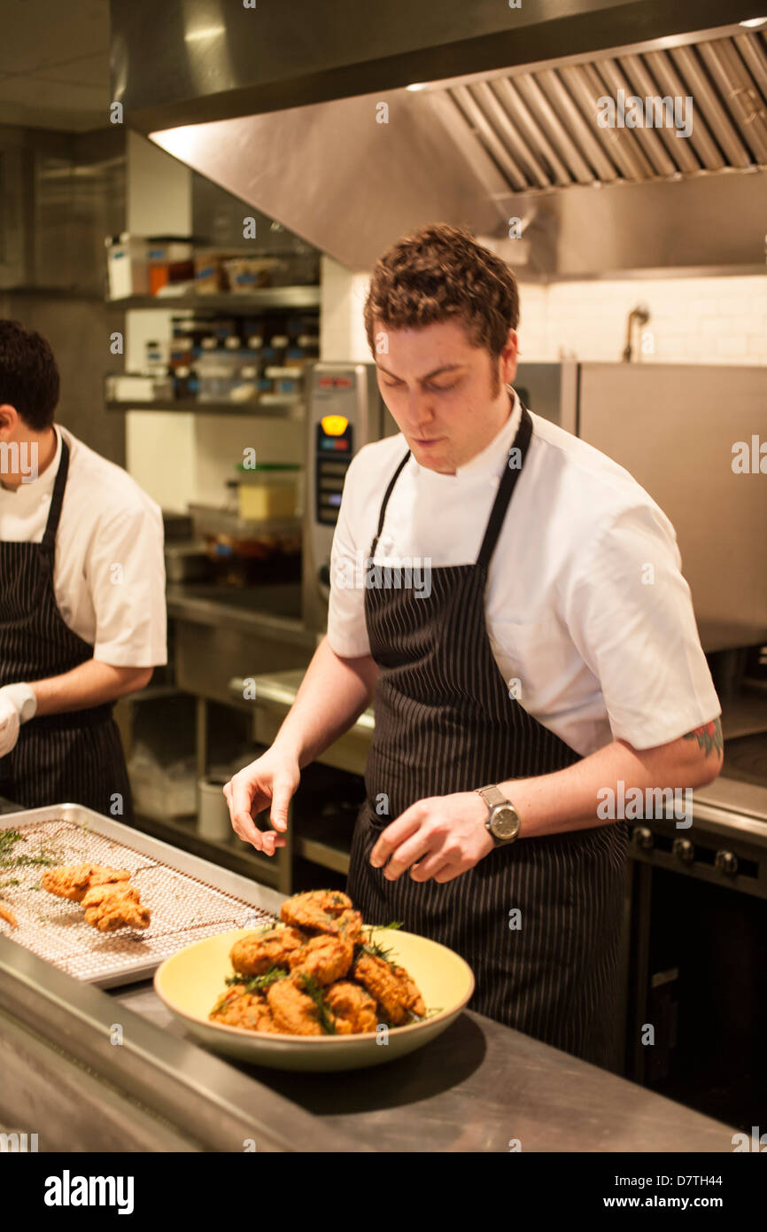 Lo Chef tenendo la benna di golden fritto di pollo Foto Stock