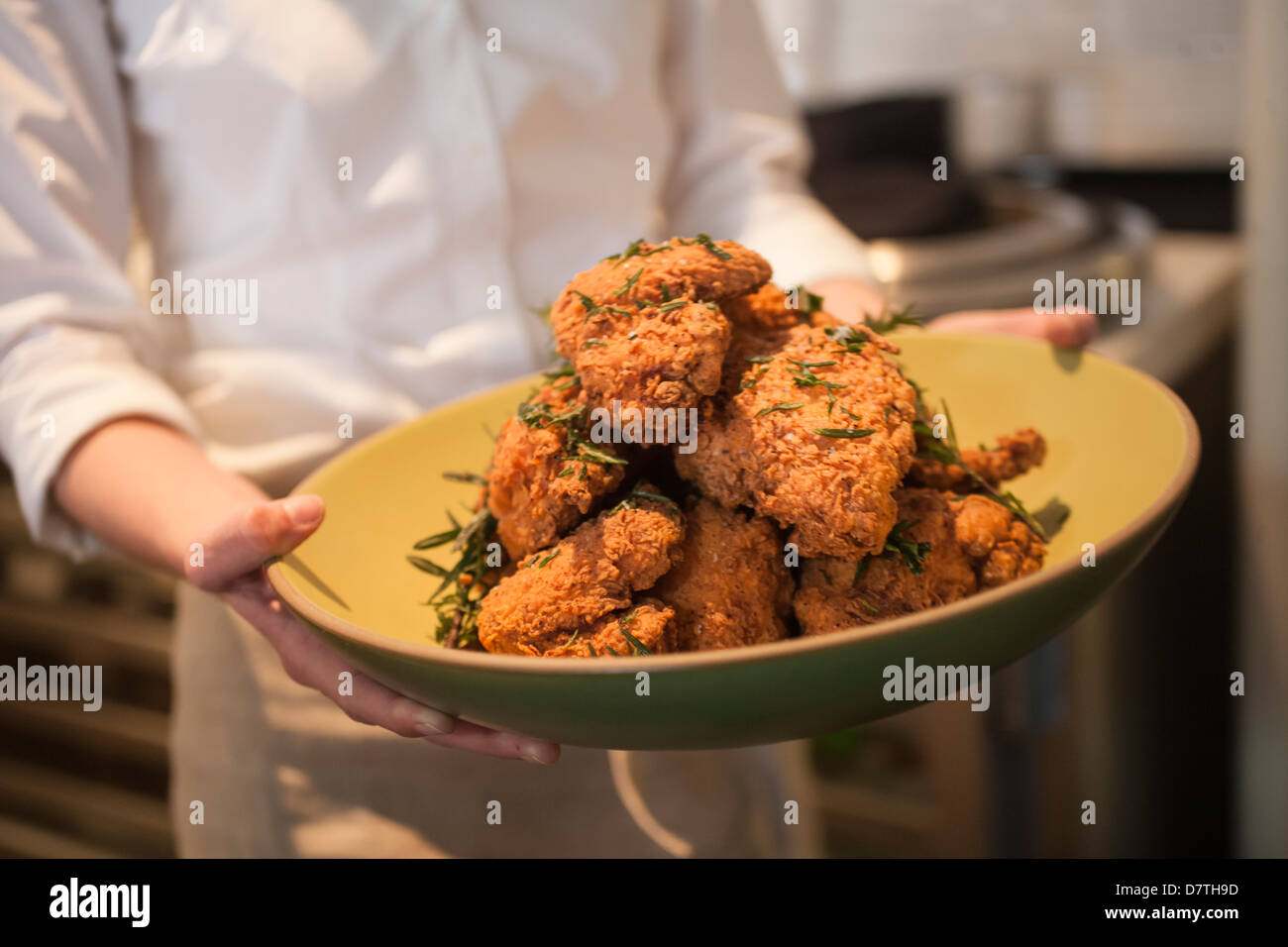 Lo Chef tenendo la benna di golden fritto di pollo Foto Stock