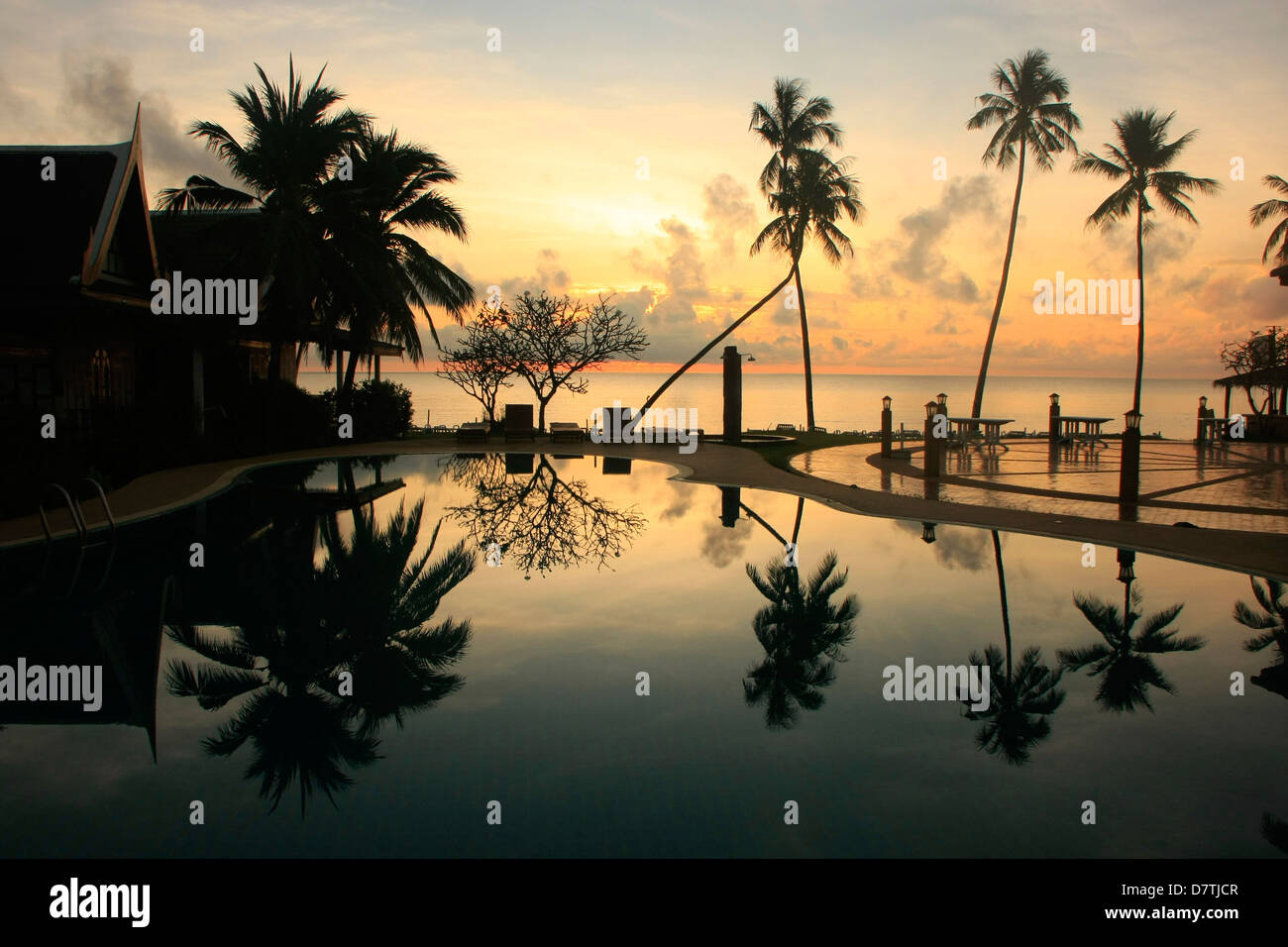 Le palme si riflette in un pool di sunrise, Ko Samui, Tailandia Foto Stock