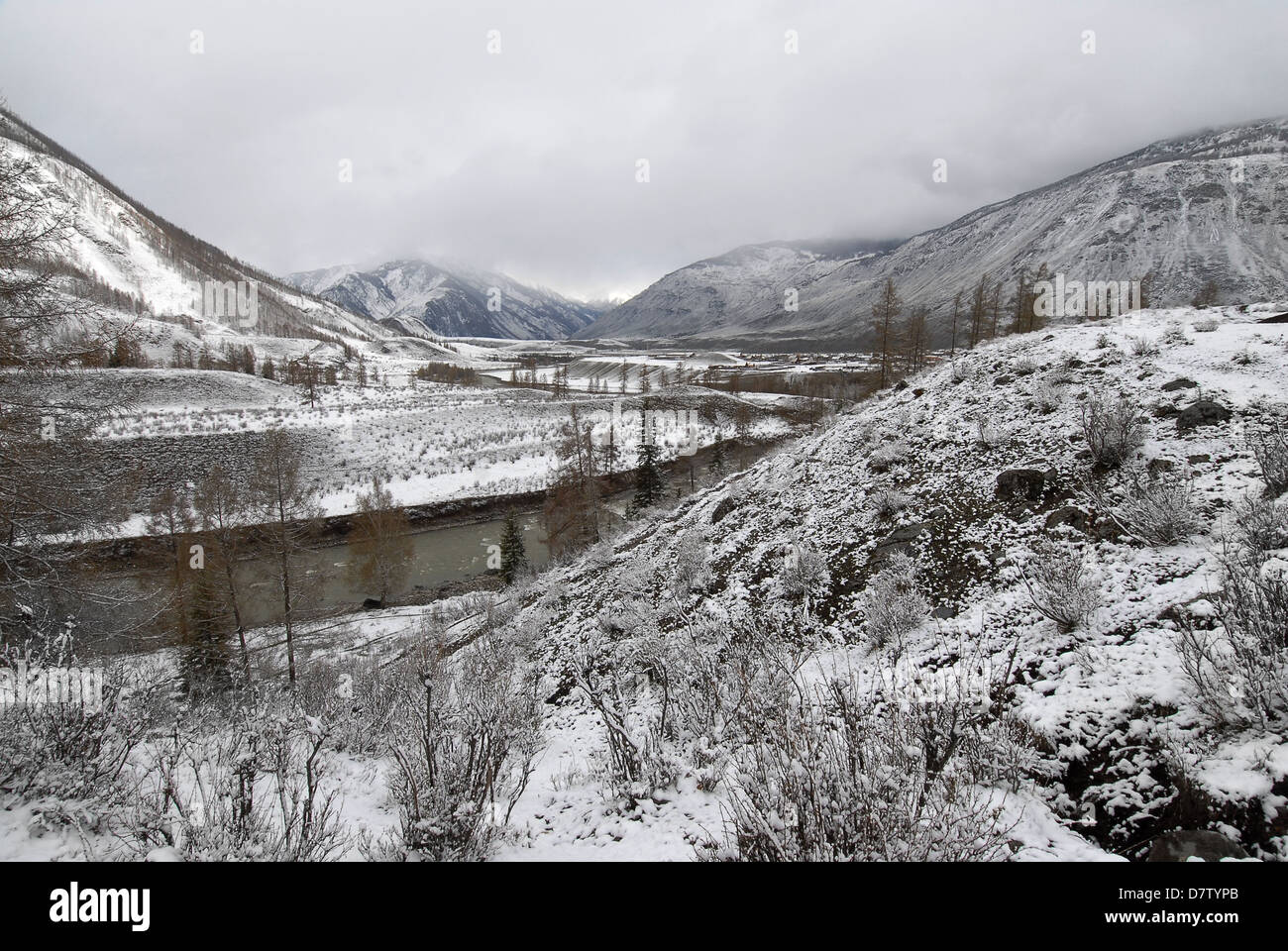 Fine neve di primavera su un fiume di montagna e un remoto villaggio nelle montagne di Altai. La Russia Foto Stock