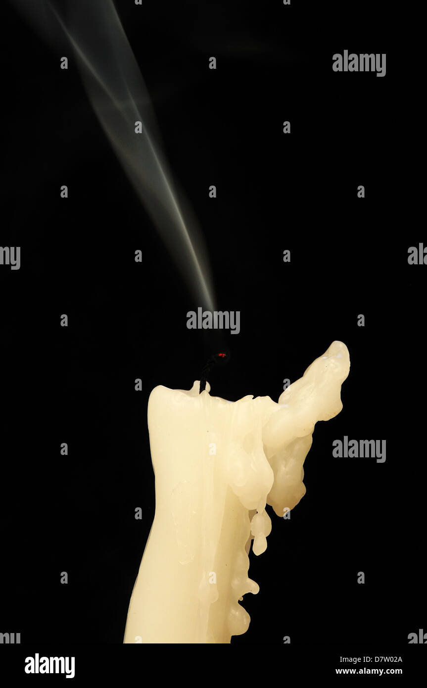 Estinta la candela contro uno sfondo nero. Foto Stock