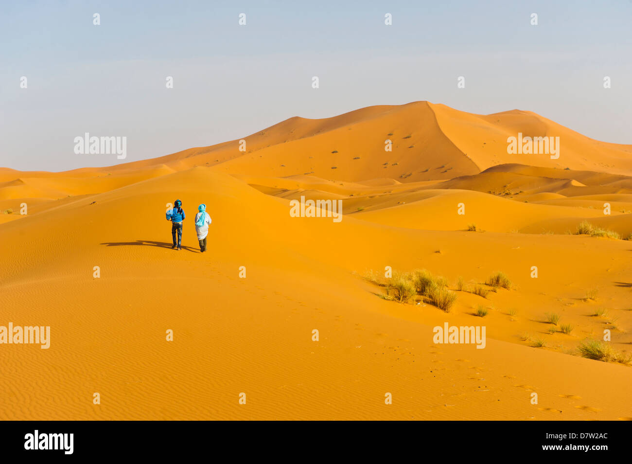 Due uomini berbera a piedi nelle dune di sabbia di Erg Chebbi Desert, Sahara Deserto vicino a Merzouga, Marocco, Africa del Nord Foto Stock