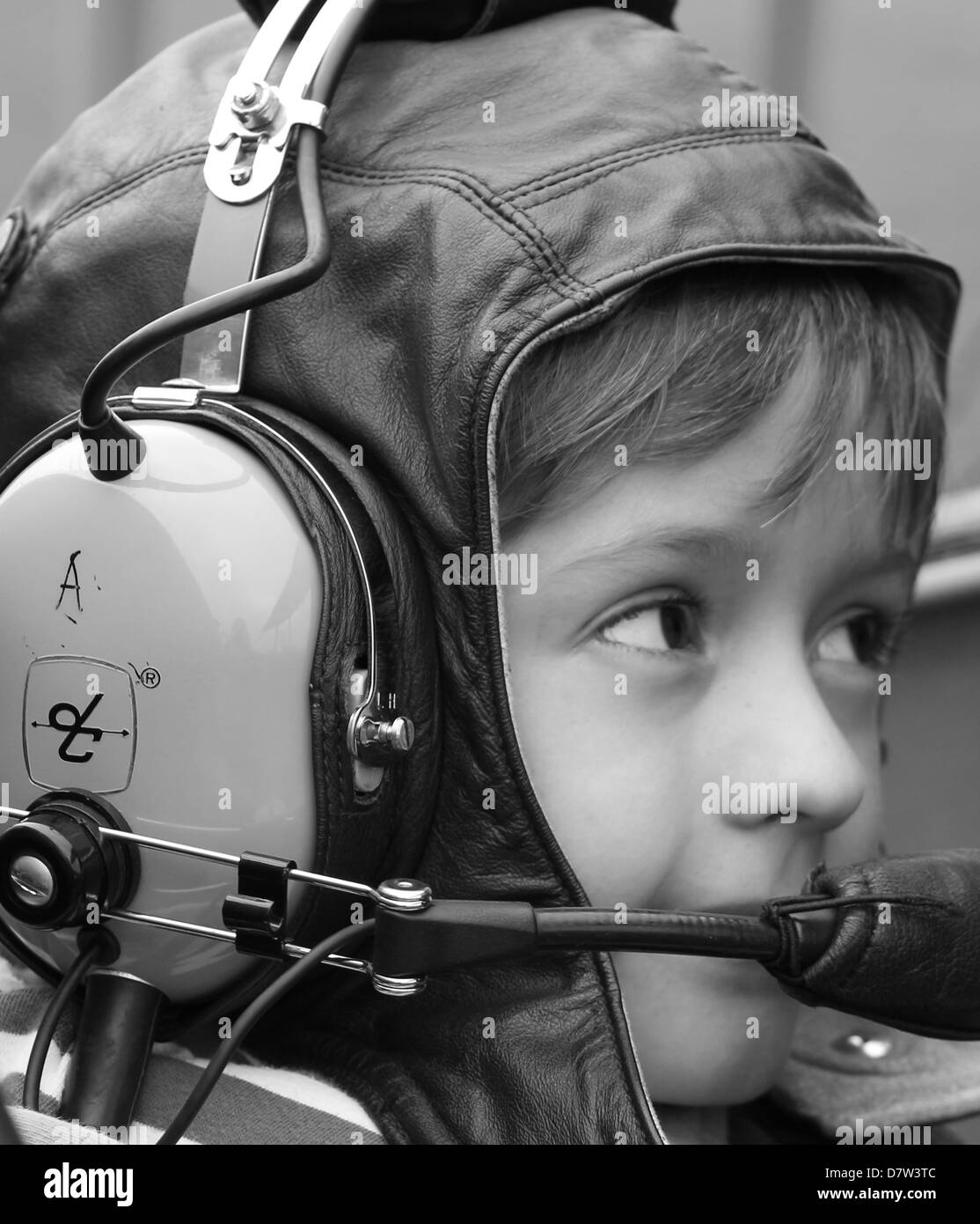Un giovane ragazzo con una ispirazione di essere un pilota di prova su un cuoio battenti hat e la cuffia. Foto Stock