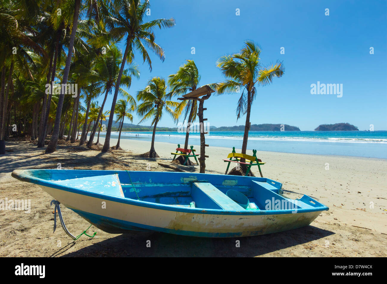 Barca sulla spiaggia orlata di palme in questo rilassato villaggio & resort, Samara, provincia di Guanacaste, Nicoya peninsula, Costa Rica Foto Stock