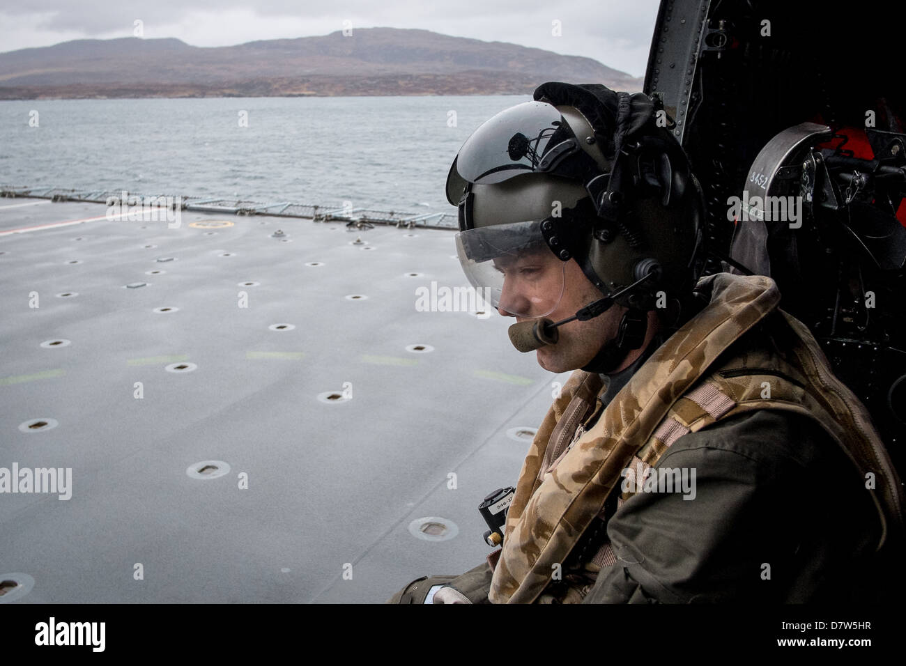 Atterraggio sul ponte di volo di HMS baluardo in un Royal Navy Sea King Mk 4 elicottero con il aircrewman guida del pilota. Foto Stock