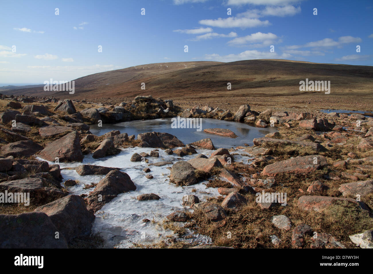 Un pool di surgelati di acqua ghiacciata, guardando verso il vertice di Ronas Hill, la montagna più alta nelle isole Shetland Foto Stock