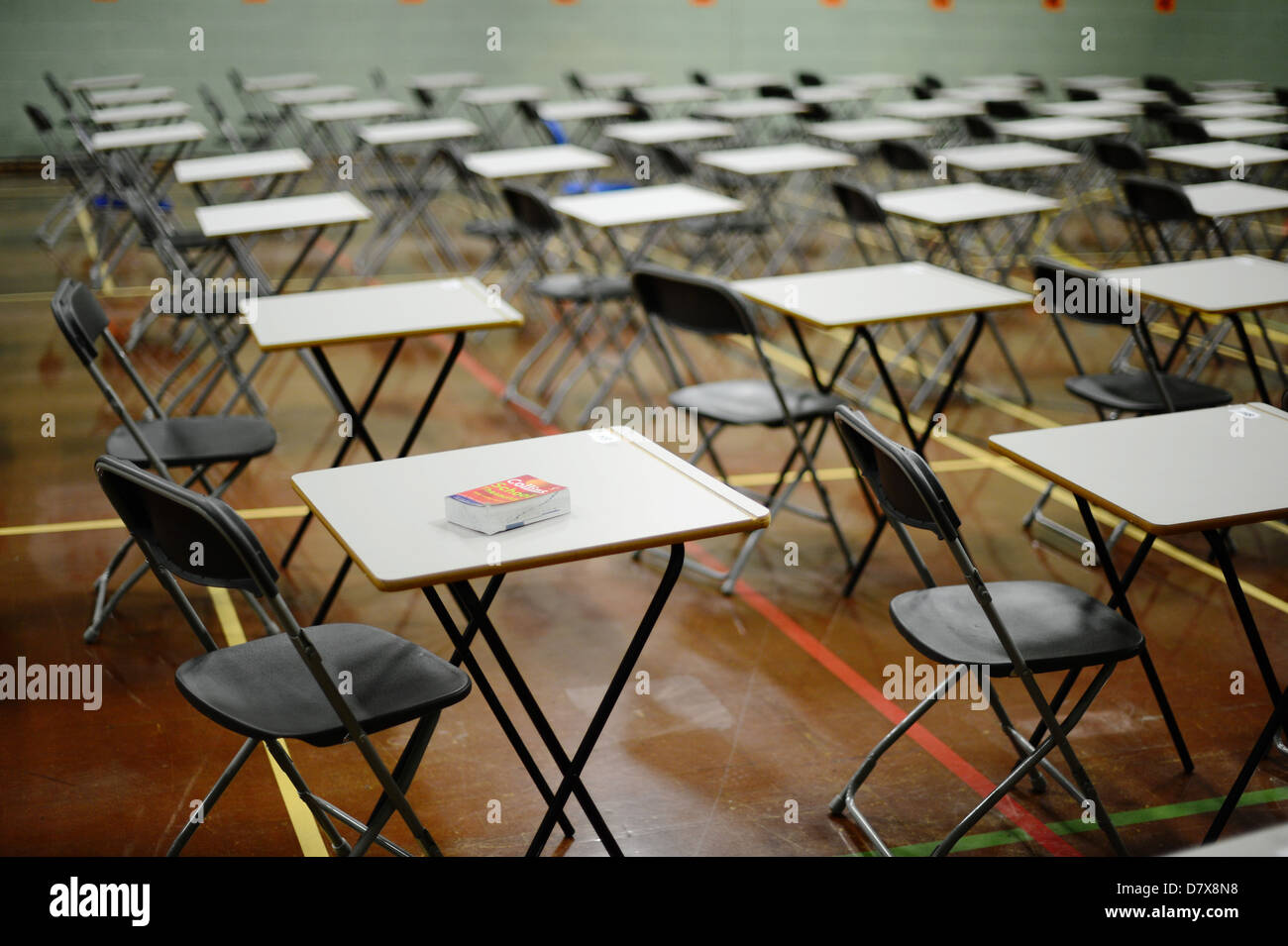 Scrivanie esposte in una sala della scuola in preparazione per l'esame tabelle vuote Foto Stock