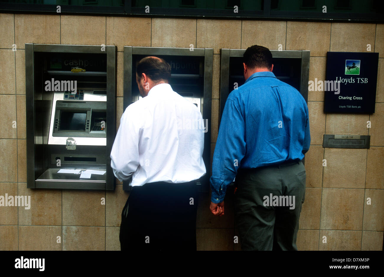 I clienti che utilizzano la Lloyds TSB bancomat a macchina, charing cross di Londra, Regno Unito. Foto Stock