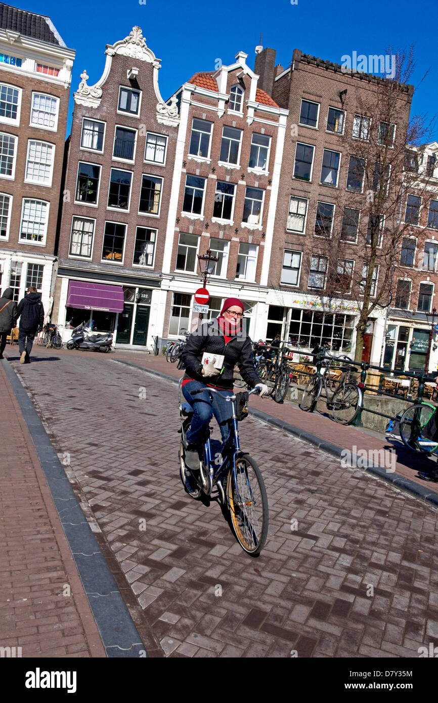 Ciclista sul ponte sul canale Prinsengracht Grachtengordel-west, Jordaan, centro di Amsterdam, Paesi Bassi Foto Stock
