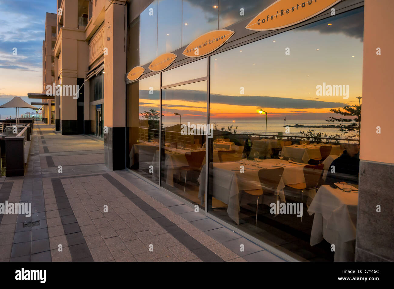 Il tramonto riflesso in un ristorante finestra a Glenelg, South Australia. Foto Stock