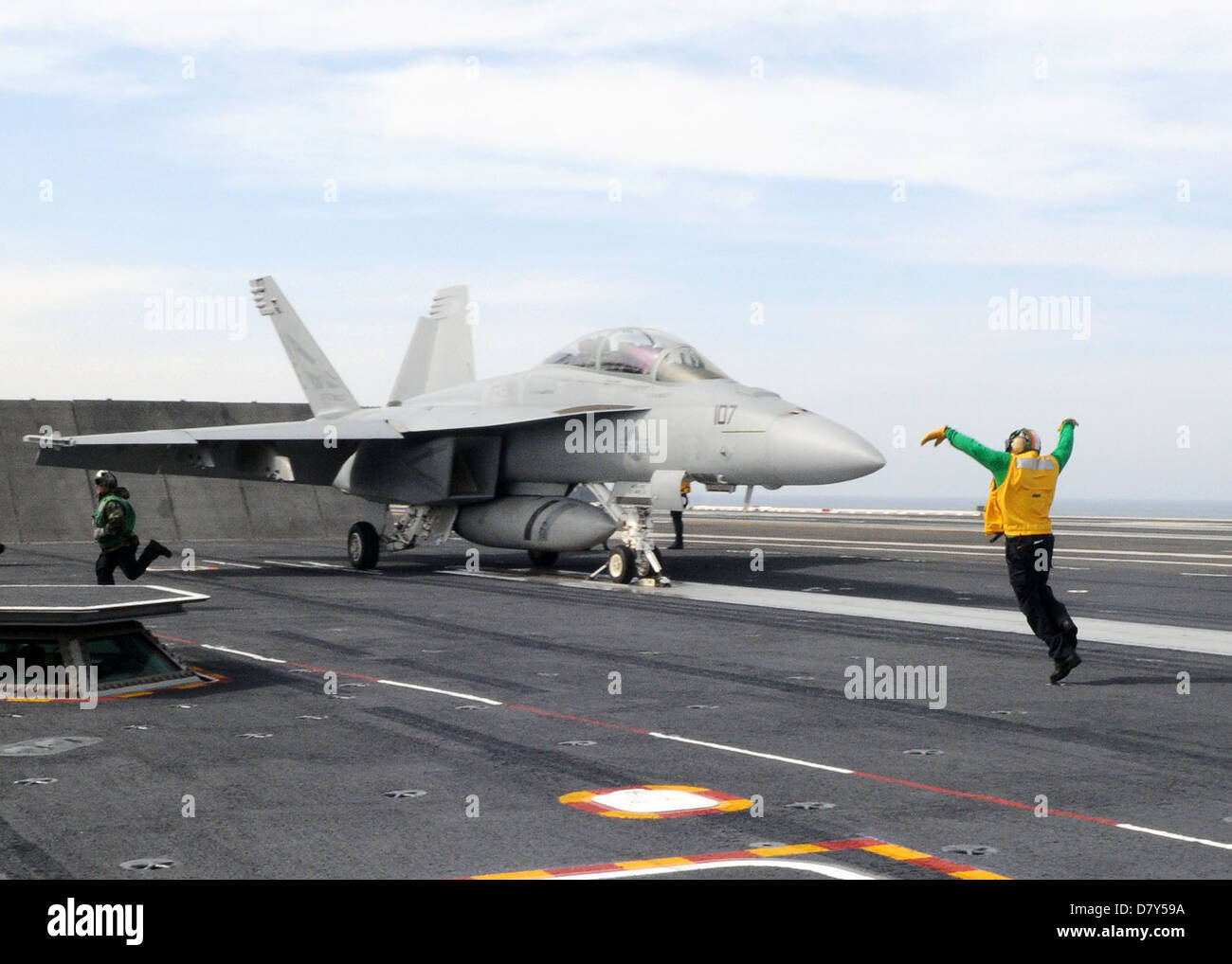 Un marinaio segnali l'F/A-18F Super Hornet. Foto Stock