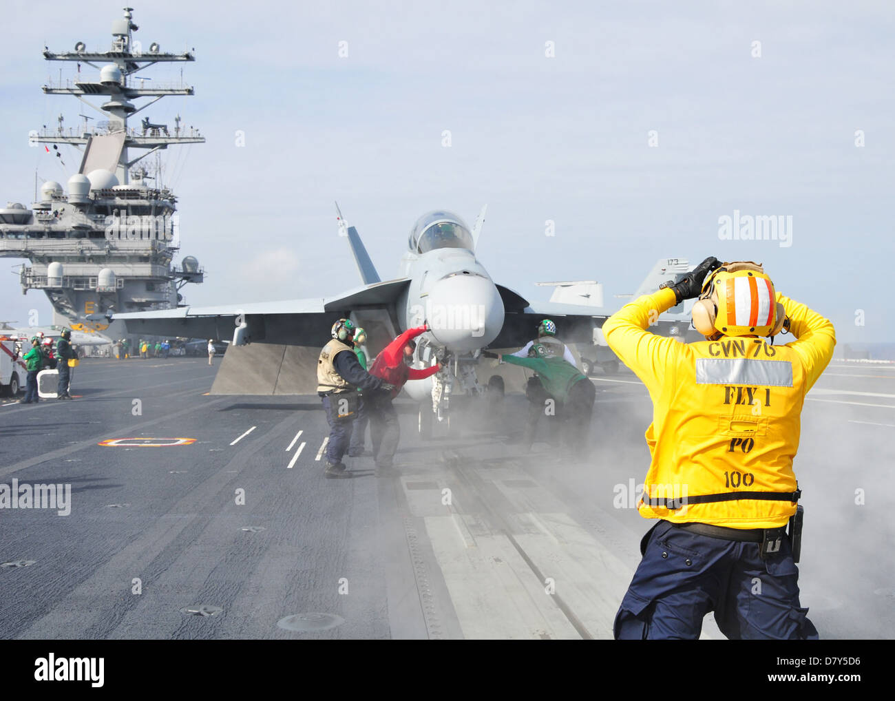 Sailor dirige un Super Hornet in mare. Foto Stock
