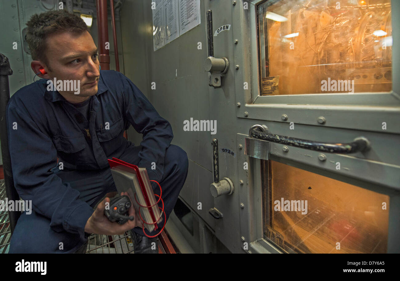 Un marinaio controlla un motore a turbina a gas. Foto Stock