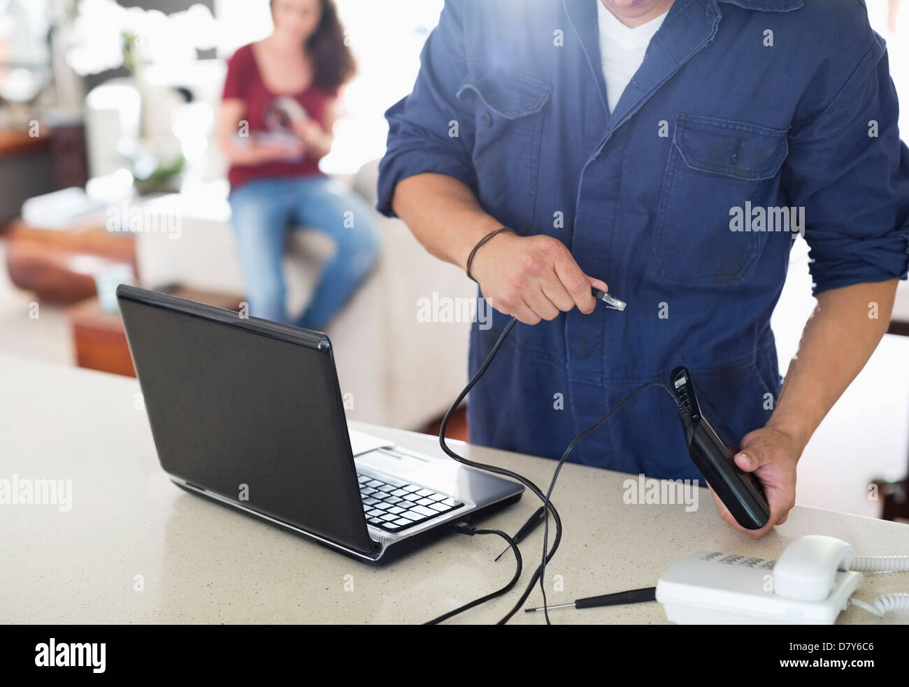 Elettricista utilizzando laptop in casa Foto Stock