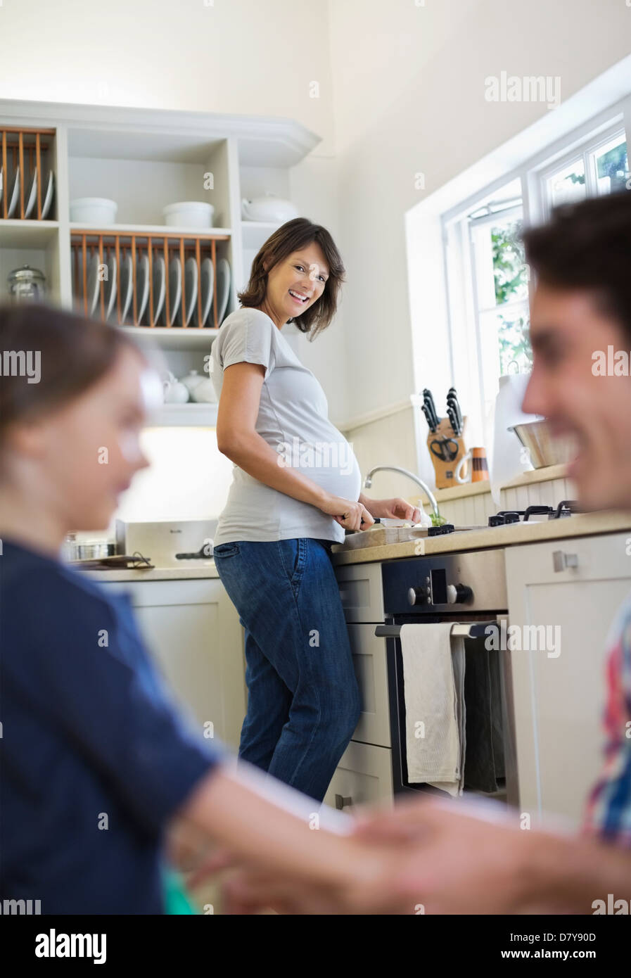 Donna incinta durante la cottura in cucina Foto Stock