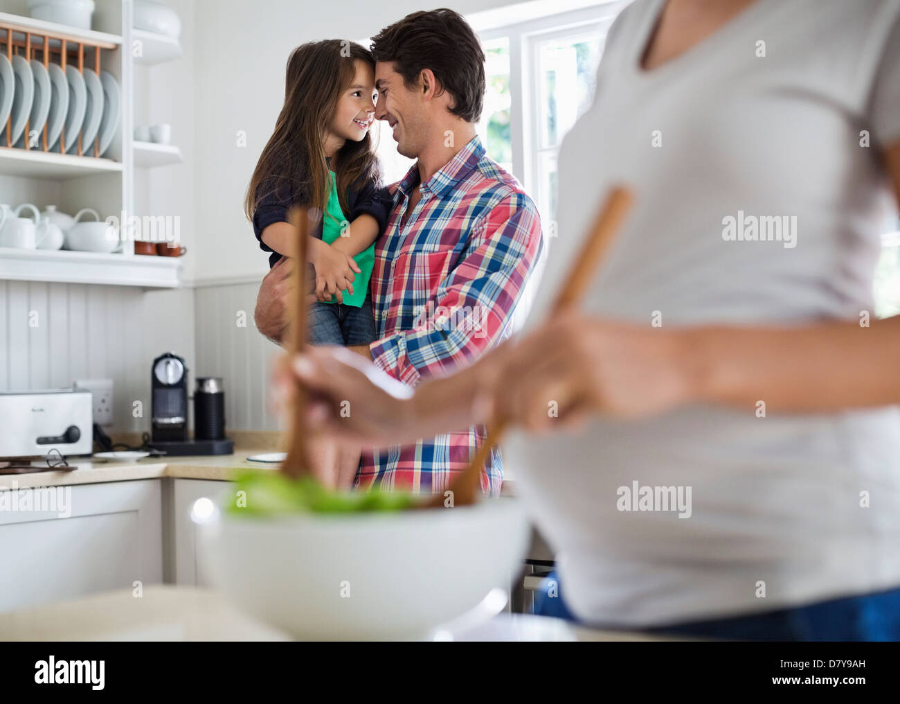 Padre e figlia toccando nasi in cucina Foto Stock
