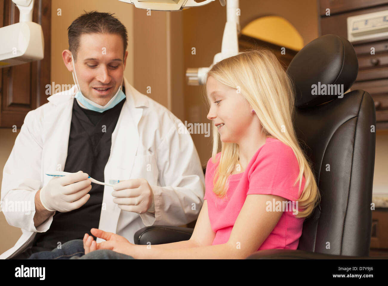 Dentista caucasica parlando a ragazza in ufficio Foto Stock
