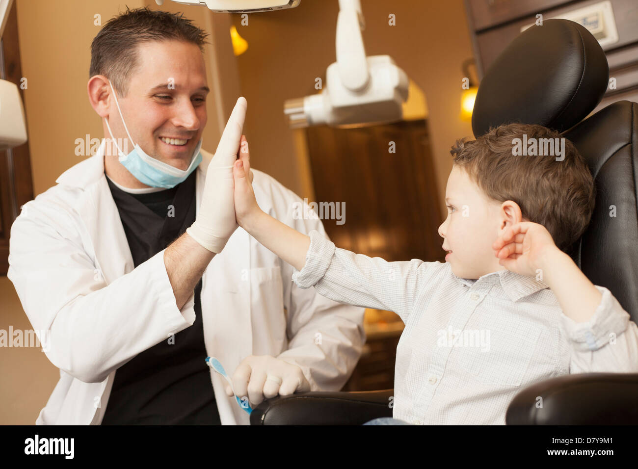 Dentista caucasica e ragazzo alto fiving in office Foto Stock