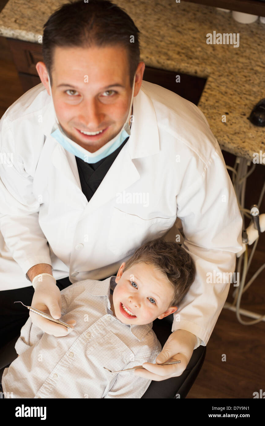 Dentista caucasica esaminando boy i denti in ufficio Foto Stock
