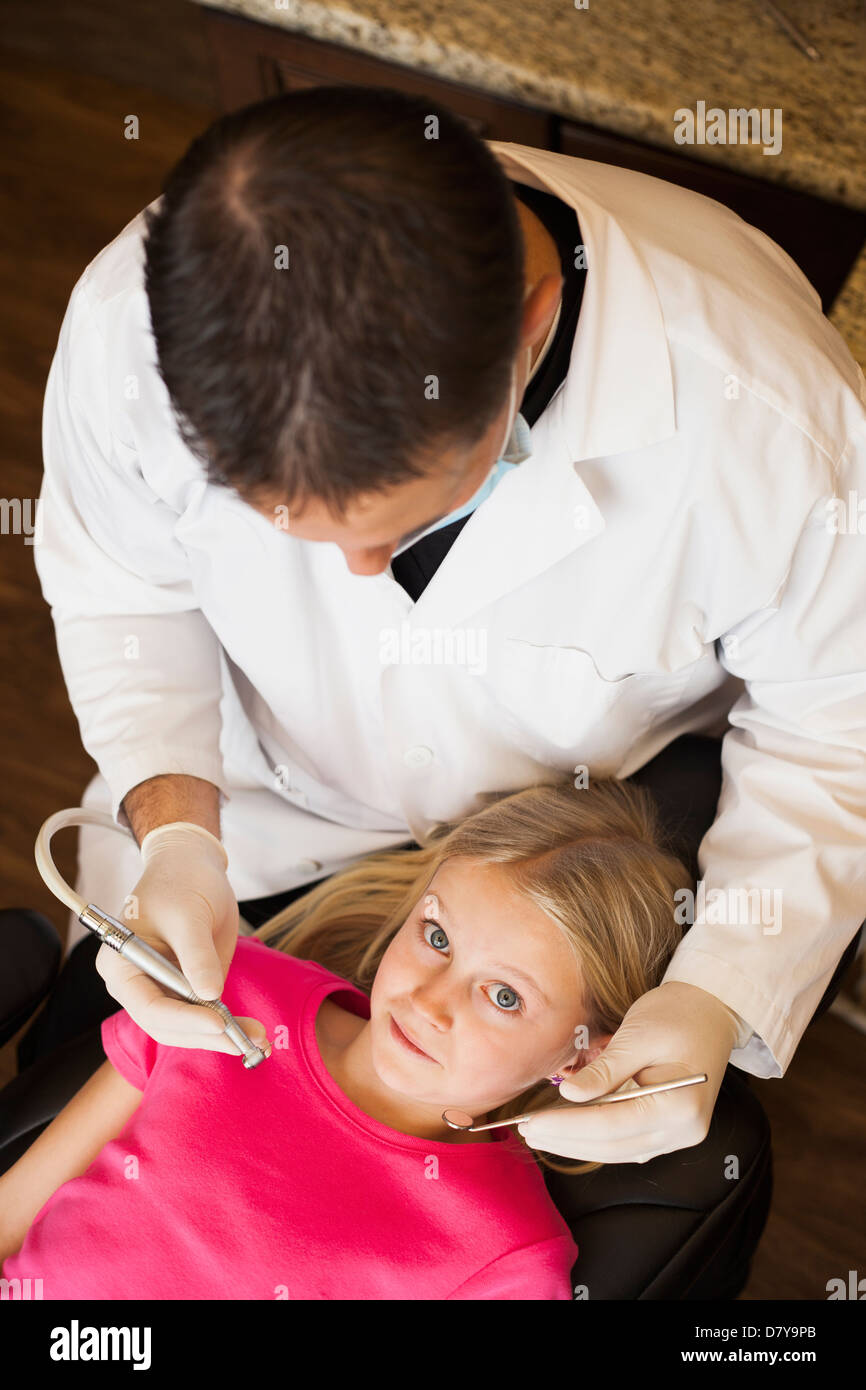 Dentista caucasica esaminando la ragazza di denti in ufficio Foto Stock