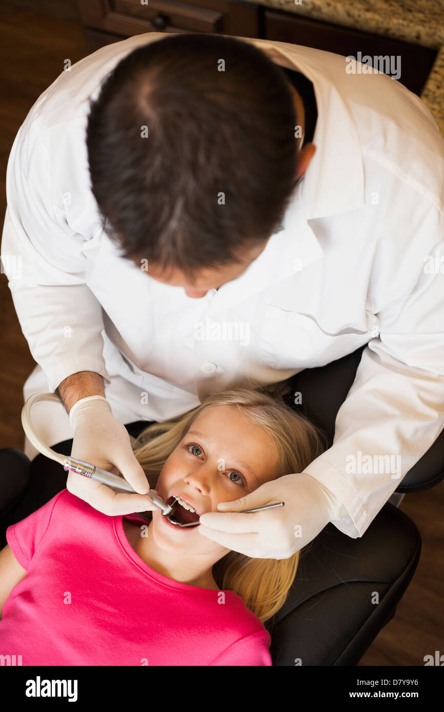 Dentista esaminando la ragazza di denti in ufficio Foto Stock