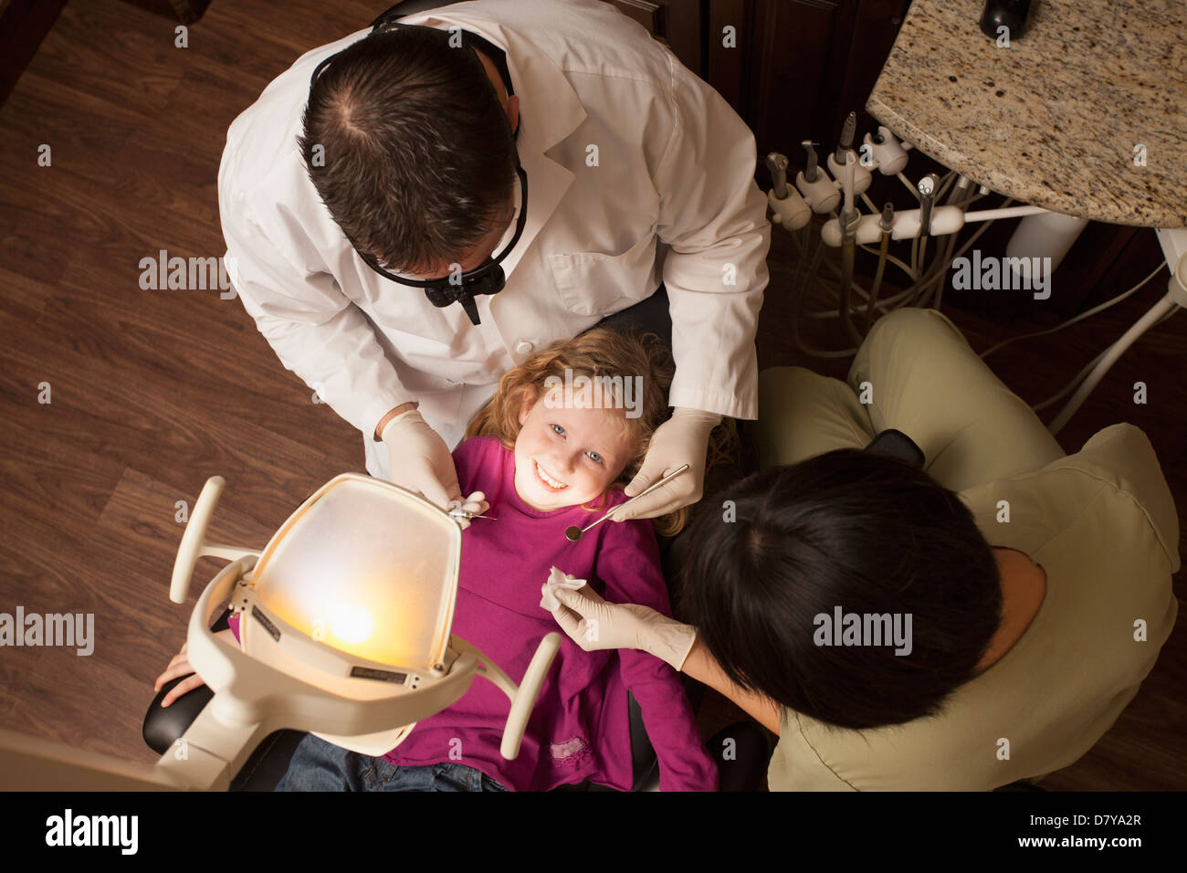Medico e infermiere esaminando la ragazza di denti in ufficio Foto Stock