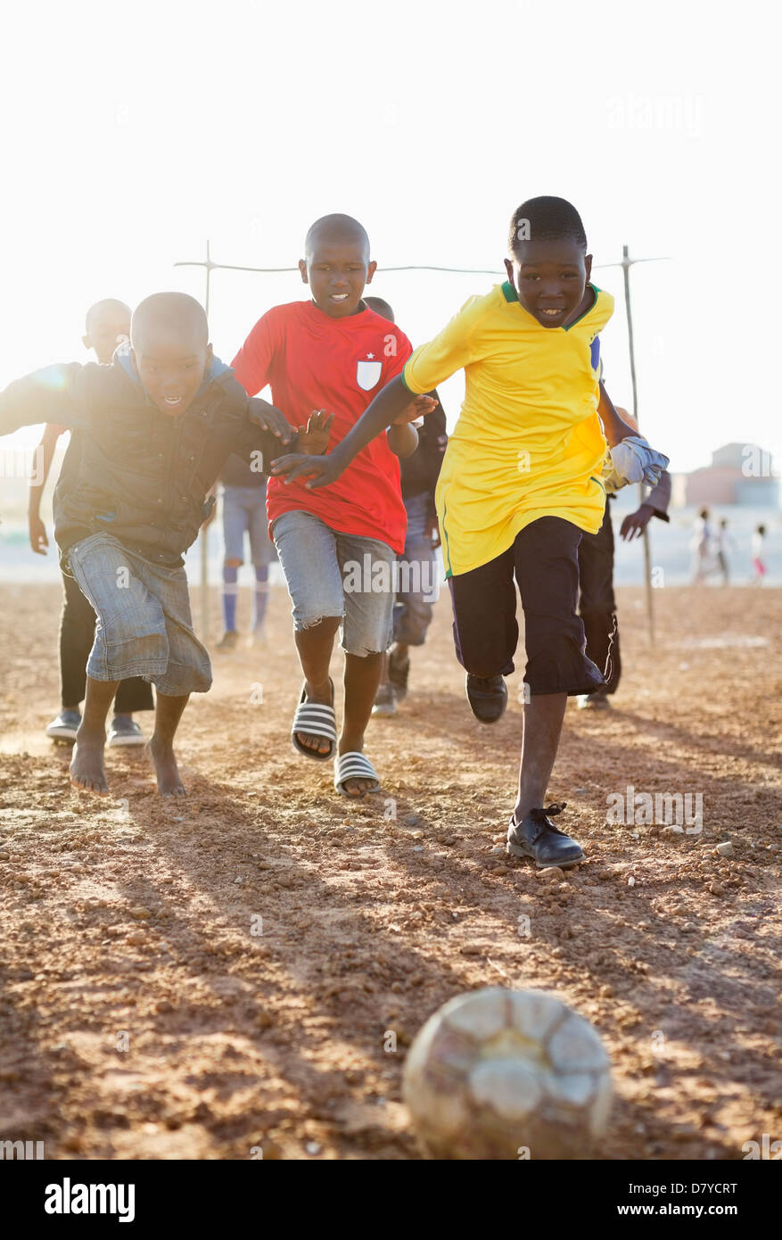 Ragazzi che giocano a calcio insieme nel campo di sporco Foto Stock