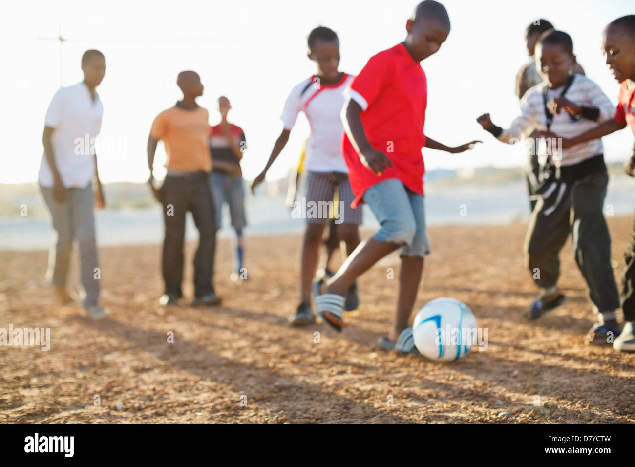 Ragazzi che giocano a calcio insieme nel campo di sporco Foto Stock