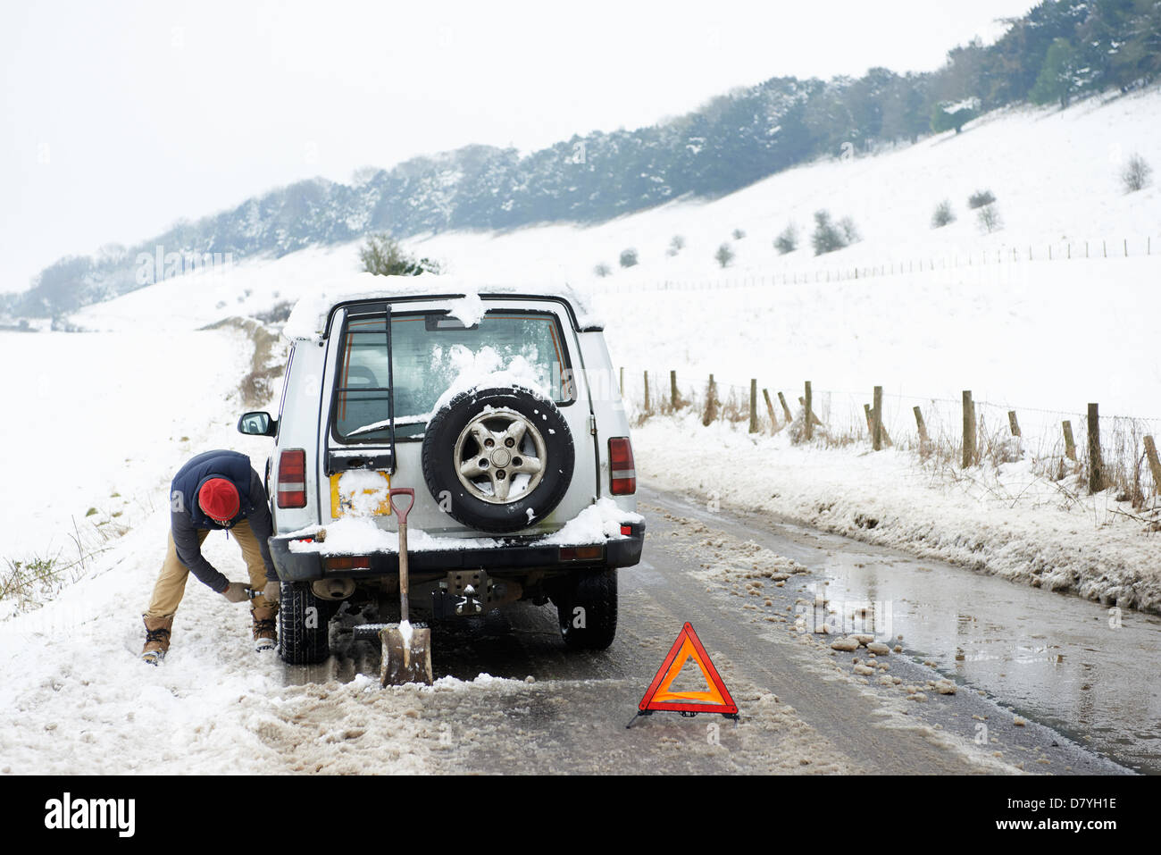 Uomo al lavoro su ripartiti in auto nella neve Foto Stock