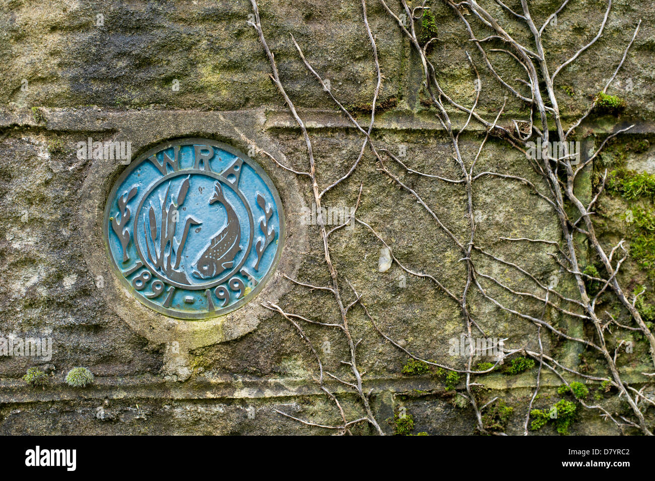 Close-up del vecchio West circolare Riding Anglers club segno (iniziali, data simbolo &) impostata nel muro di pietra - Burley in Wharfedale, nello Yorkshire, Inghilterra, Regno Unito. Foto Stock