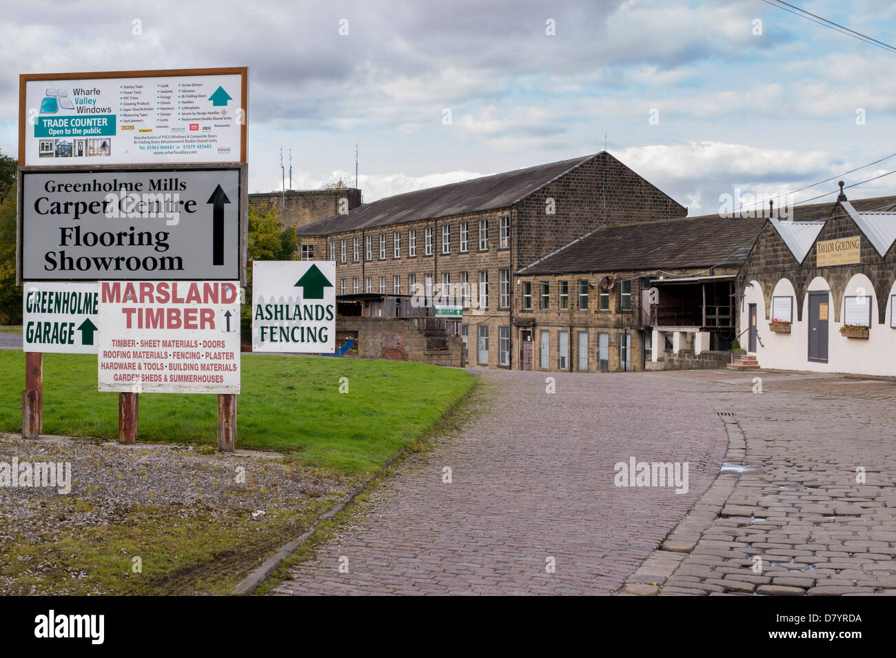 Indicazioni & strada basolata di mulini Greenholme Trading Station Wagon, storico mulino usato dalla varietà delle moderne aziende - Burley in Wharfedale, Inghilterra, GB, UK. Foto Stock