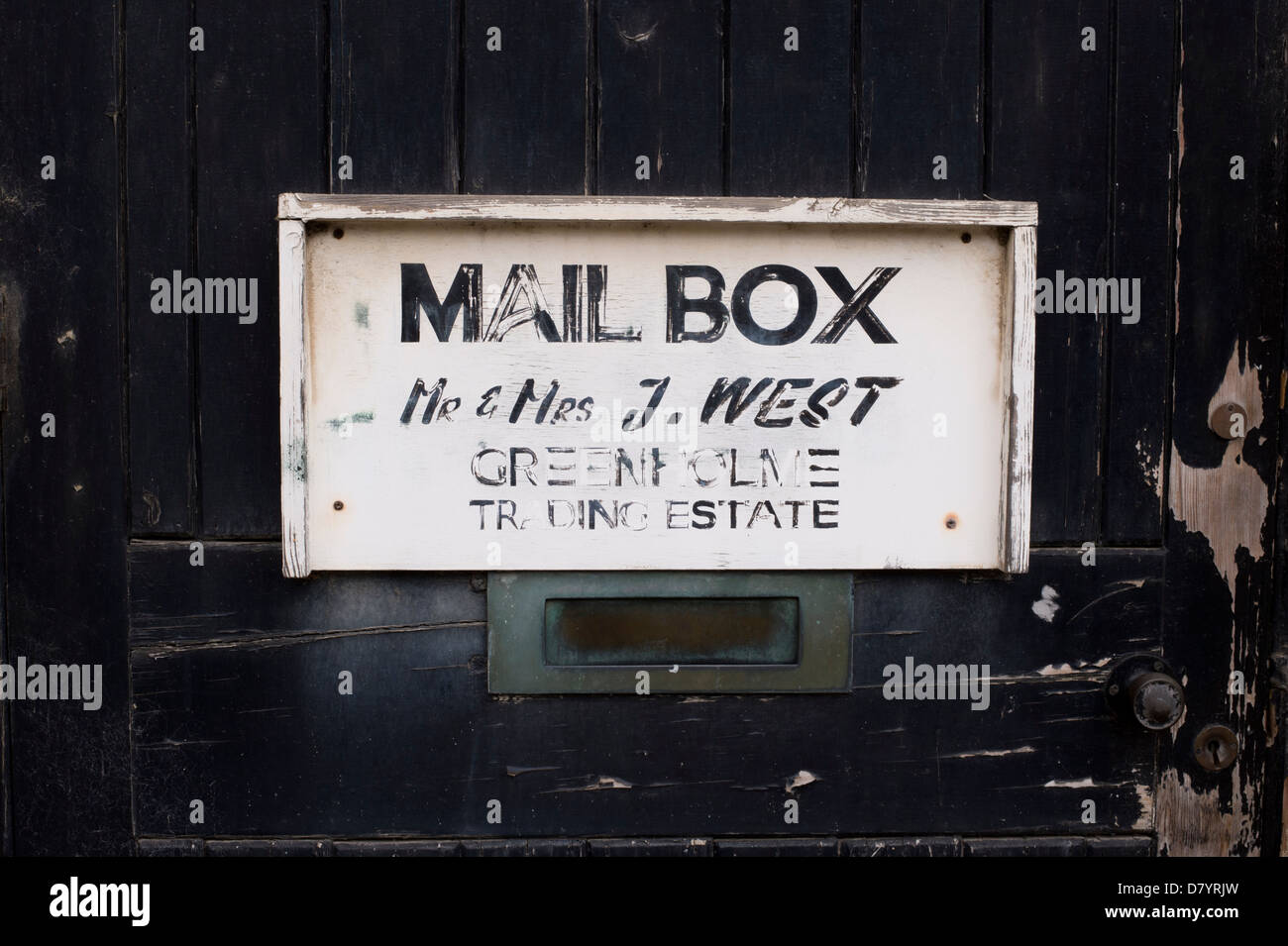 Close-up del vecchio cartello in legno posizione di marcatura della casella di posta elettronica per il signor e la signora West montato sulla porta di legno con sfald vernice - vicino a Ilkley, Inghilterra, GB, UK. Foto Stock