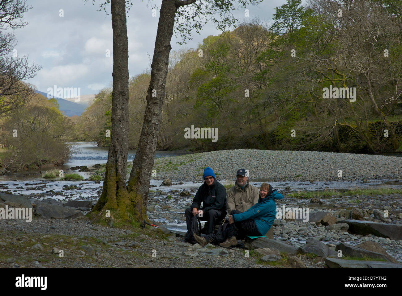 Tre escursionisti in appoggio sul fiume Derwent, in Borrowdale, Parco Nazionale del Distretto dei Laghi, Cumbria, England Regno Unito Foto Stock