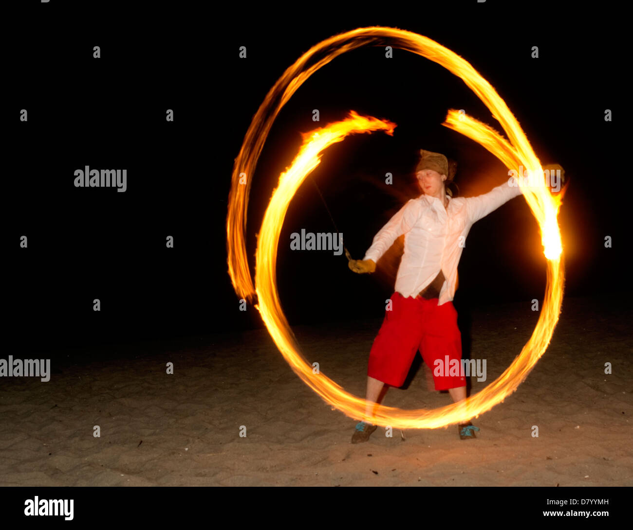 Un uomo festeggia il nuovo anno il suo modo accogliendo nuove sfide ballando e giocando con il fuoco la filatura Foto Stock