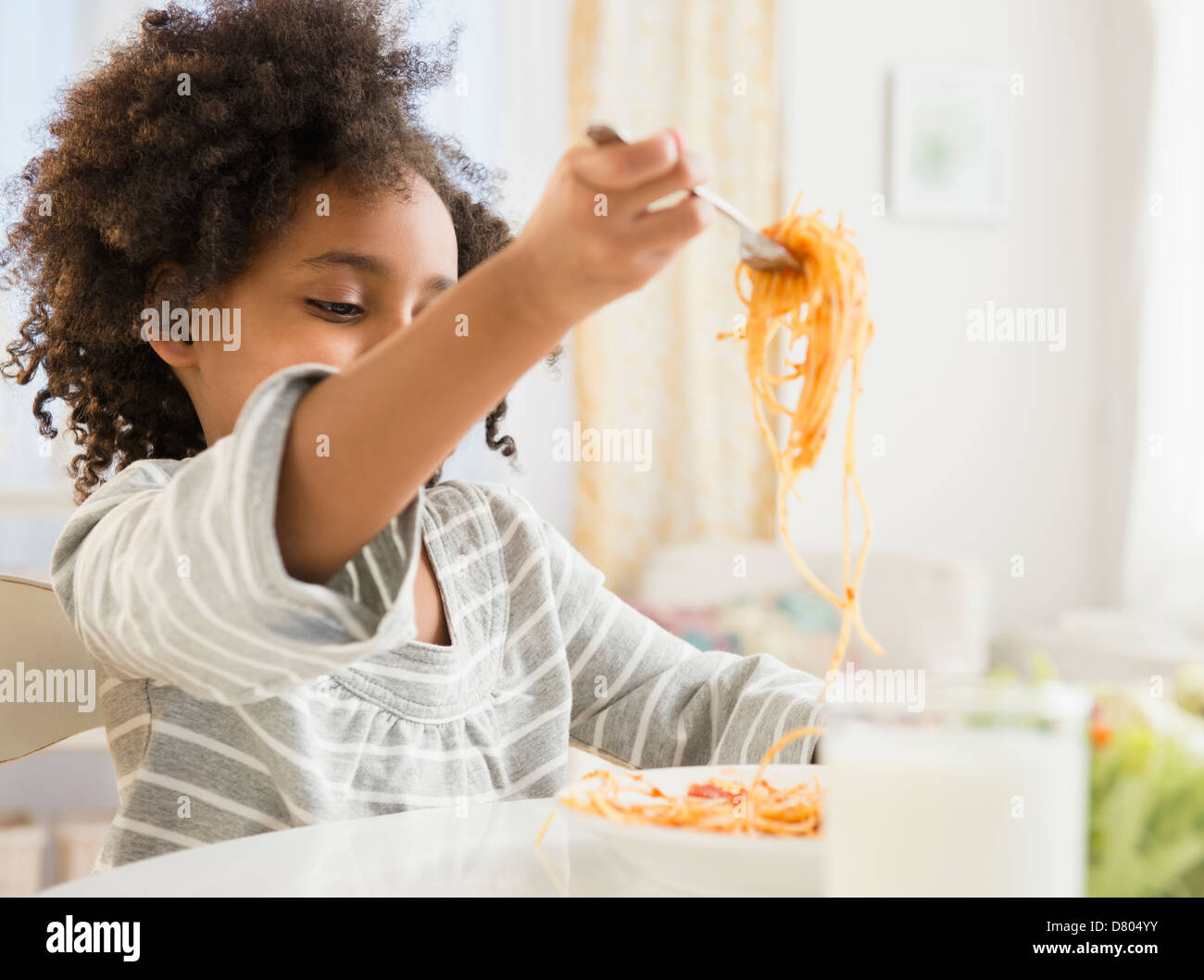 African American Girl mangiare piatto di spaghetti Foto Stock