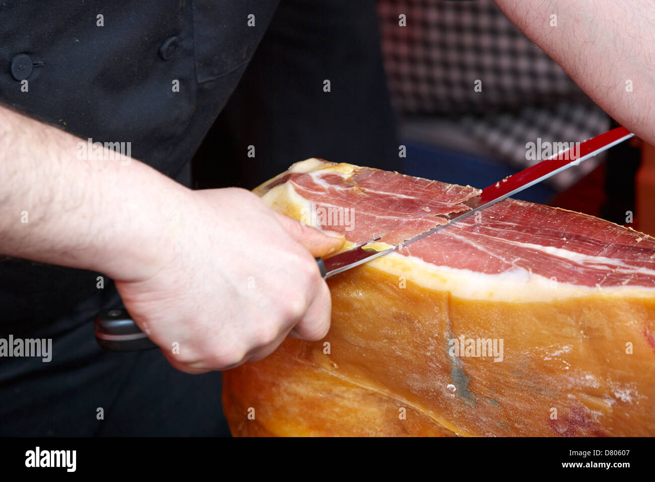L uomo per affettare sottilmente prosciutto Serrano Foto Stock