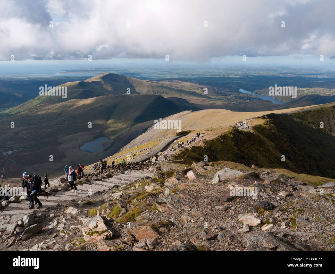 La vista da NW Snowdon il vertice, che mostra gli escursionisti sulla parte superiore raggiunge la trafficata via Llanberis Foto Stock