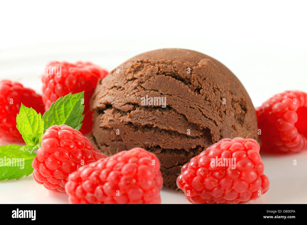 Scoop di gelato al cioccolato con lamponi freschi Foto Stock