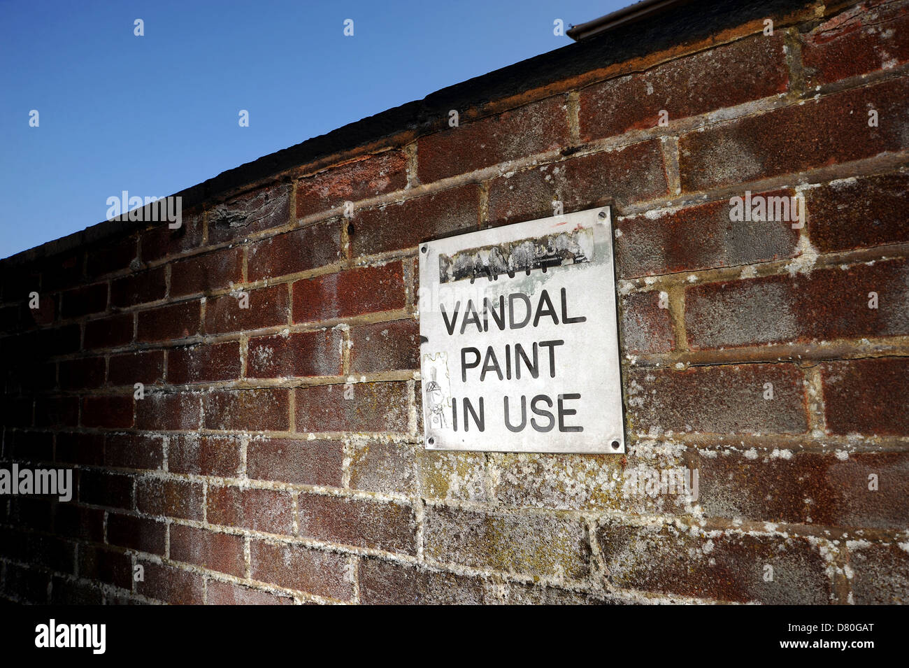 Anti vandalo in vernice utilizzare il segno su un muro di mattoni Foto Stock