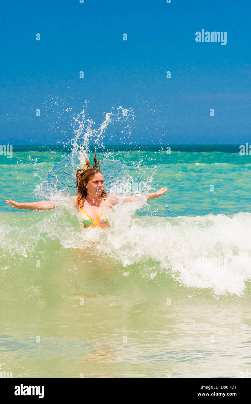 La donna caucasica di quarantacinque anni godendo di spruzzi di acqua e di divertimento in una spiaggia della Florida Foto Stock