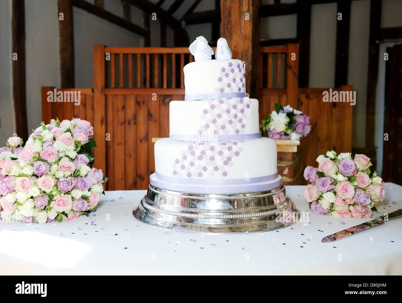 Torta di Nozze sul tavolo della reception con fiori Foto Stock