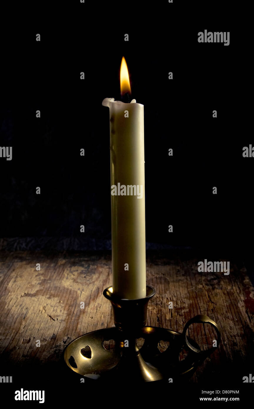 Una candela in un vecchio candelabro Foto Stock