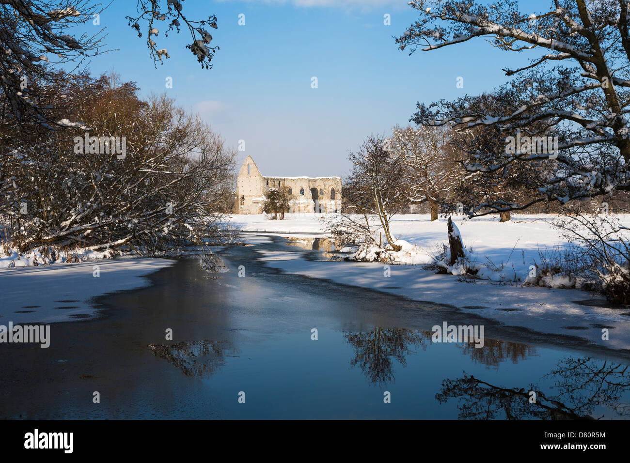 Newark Priory, sciolto da Enrico VIII, nella luce del sole nella neve con un cielo blu - Pyrford, Surrey, Inghilterra, con il fiume Wey Foto Stock