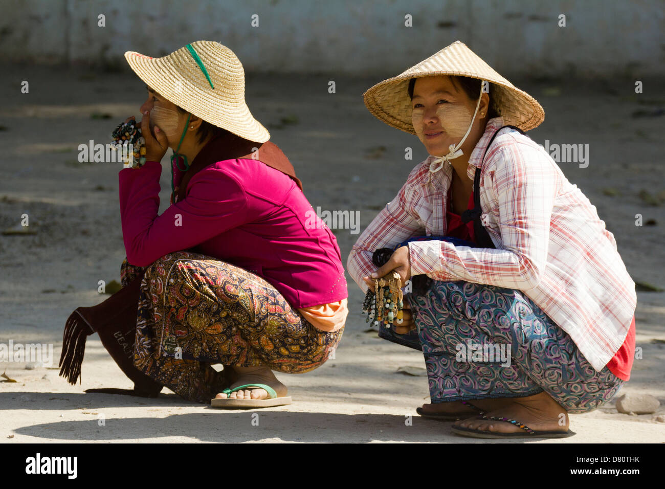 Due ragazze squatting in strada a Mingun, Myanmar Foto Stock