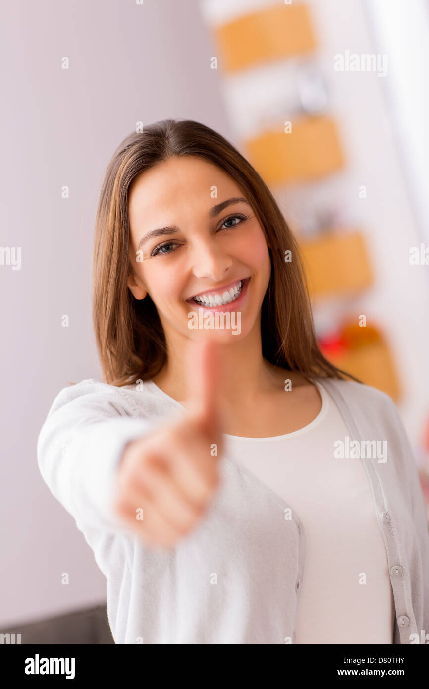 Immagine luminosa della giovane donna con il pollice in alto Foto Stock