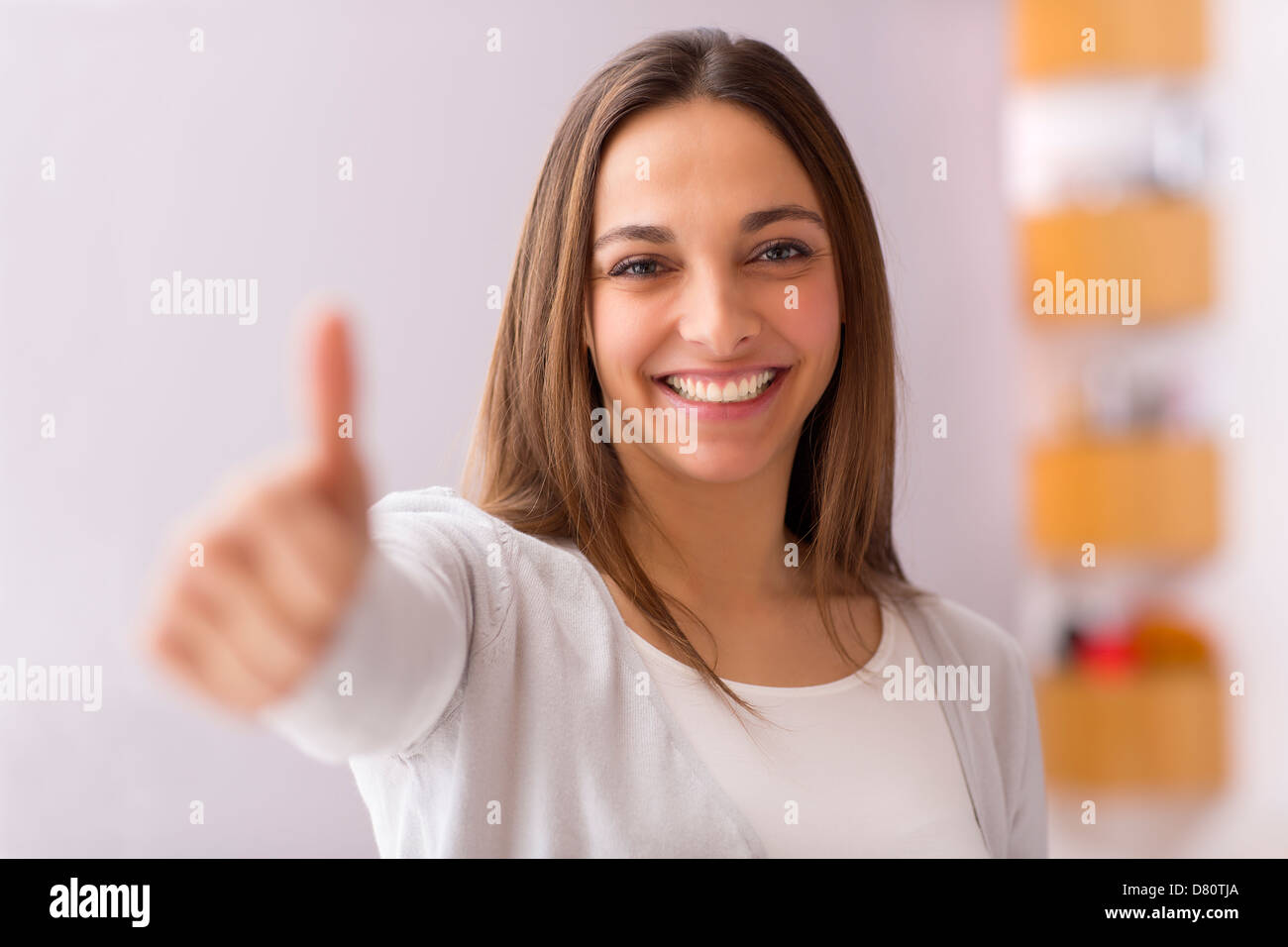 Immagine luminosa della giovane donna con il pollice in alto Foto Stock